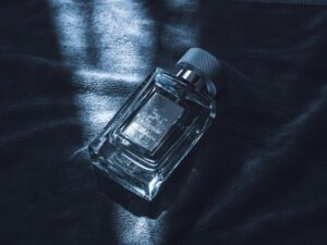 An artistic shot of a luxury perfume bottle resting on textured fabric, emitting sophistication.